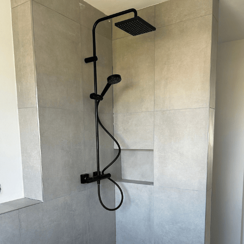 Ademi Heizungsmonteur aus Delmenhorst Klempner (7) Ebenerdige Dusche mit schwarzer Armatur und großformatigen Fliesen von Ademi Sanitär